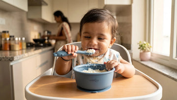 Indian baby eating curd-rice from a Cubkins blue olive silicone suction bowl