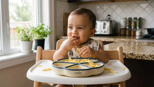 Indian baby self-feeding scrambled egg from a Cubkins silicone suction plate