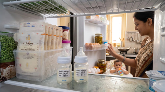 Cubkins temp-sensing breast milk storage bags filed flat in a freezer beside labelled bottles