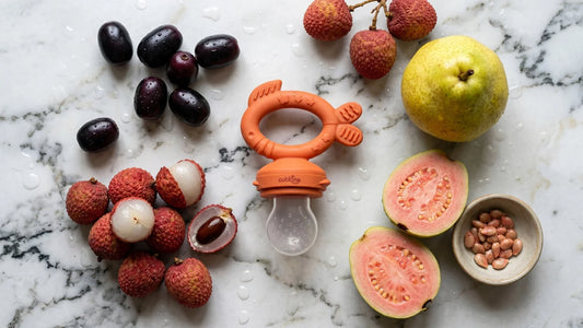 Indian baby using BIS Certified silicone fruit feeder with guava in highchair during monsoon — Cubkins