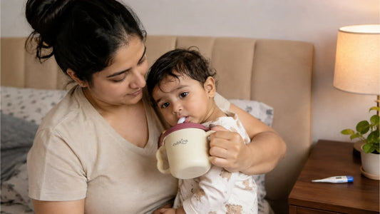 Mother offering water in a Cubkins straw training cup to her feverish baby