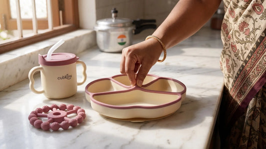 Parent pinch-testing a Cubkins 100% food-grade silicone suction plate, cup and teether nearby
