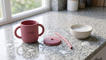 Cubkins silicone straw training cup dismantled into cup, lid and straw beside a straw brush on an Indian kitchen counter