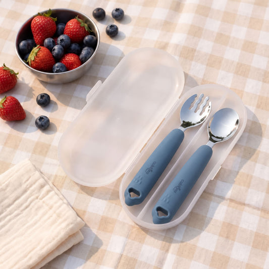 Cubkins blue olive 304 steel toddler spoon and fork in an open frosted travel case on a picnic blanket