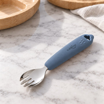 Cubkins 304 stainless steel toddler fork with blue olive silicone handle on a marble counter