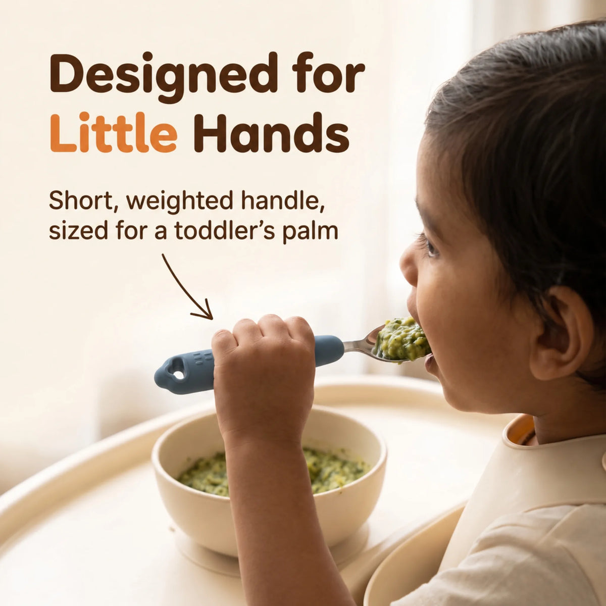 Toddler holding the Cubkins blue olive steel baby spoon in a palmar grasp and eating spinach khichdi