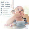 Happy toddler self-feeding from the Cubkins snack cup; features a lightweight design and secure suction base.