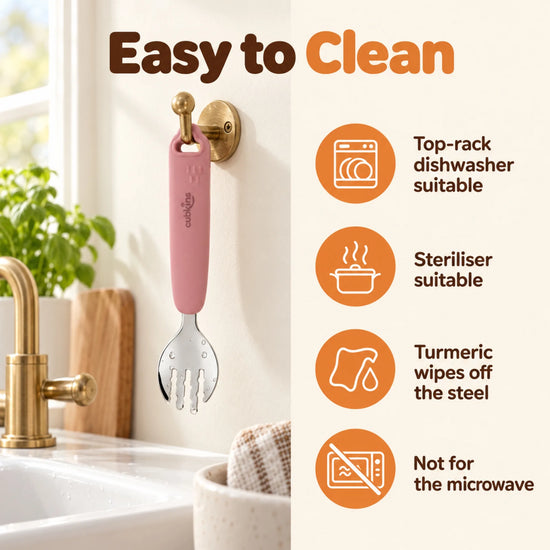 Cubkins raspberry steel toddler fork hanging to dry by its loop, with care icons: top-rack dishwasher, steriliser, turmeric wipes off, not for microwave