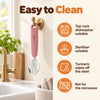 Cubkins raspberry steel toddler fork hanging to dry by its loop, with care icons: top-rack dishwasher, steriliser, turmeric wipes off, not for microwave