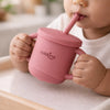 Indian baby holding and drinking independently from the Cubkins silicone straw cup in Raspberry, seated in a high chair