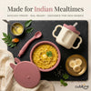 Flatlay of Cubkins raspberry baby feeding set with khichdi in suction bowl, bendable spoon, and training cup styled on a dark slate board with turmeric, curry leaves, and banana — khichdi-proof, dal-ready.