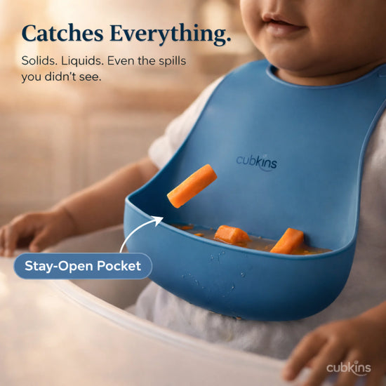 Cubkins blue silicone bib demonstrating stay-open pocket design catching solids and liquids during baby feeding