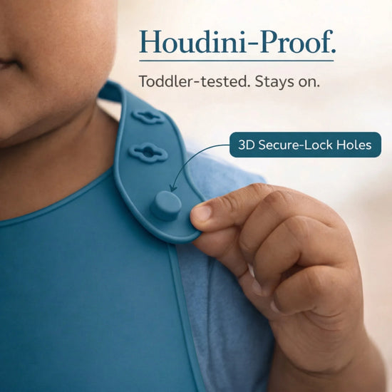 Close-up of Cubkins blue bib Houdini-proof 3D secure-lock holes showing toddler-tested closure system that stays on
