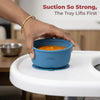 Hand demonstrating strong suction of Cubkins blue baby bowl lifting from white tray with pureed food inside