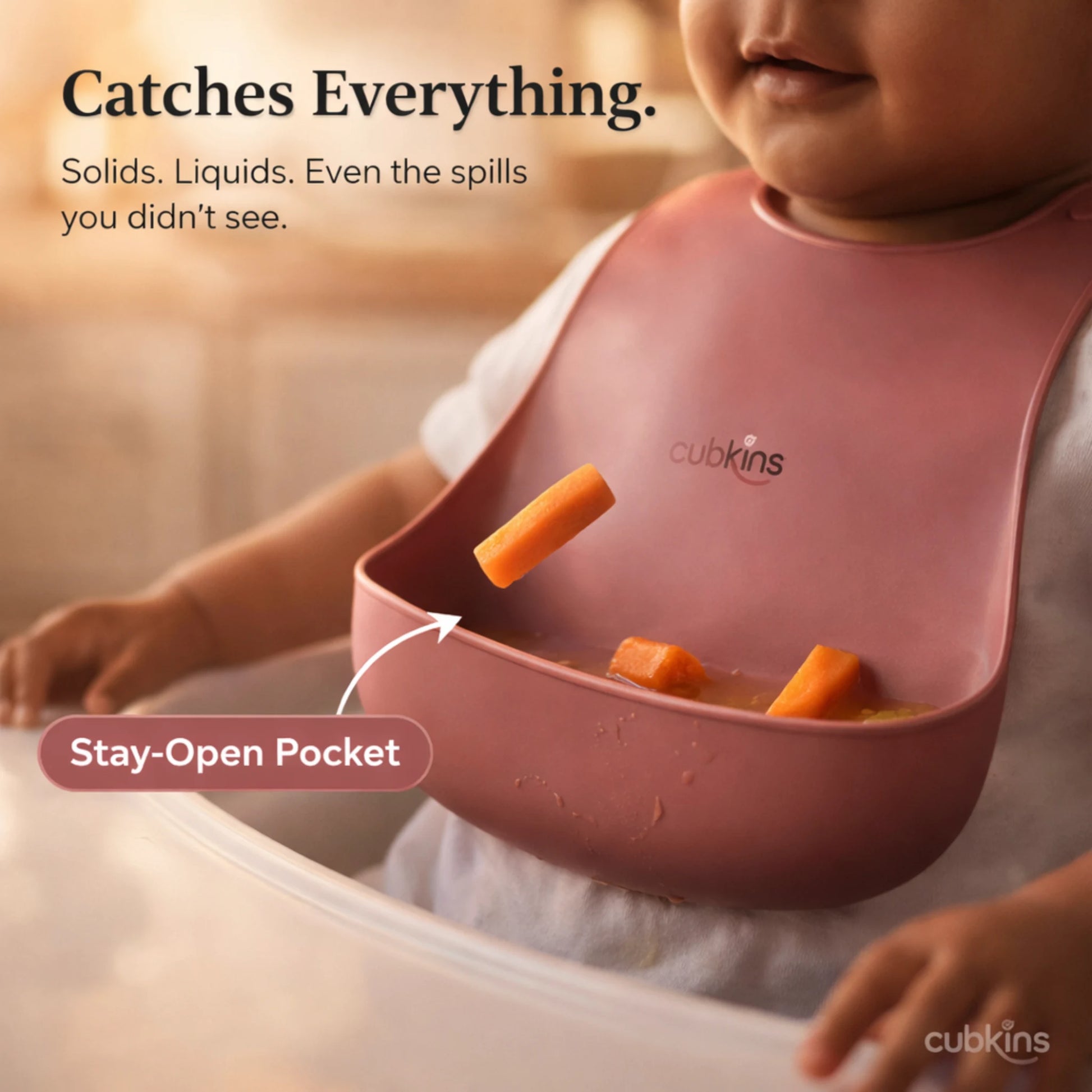 Cubkins raspberry silicone bib in action showing stay-open pocket catching food pieces during toddler mealtime