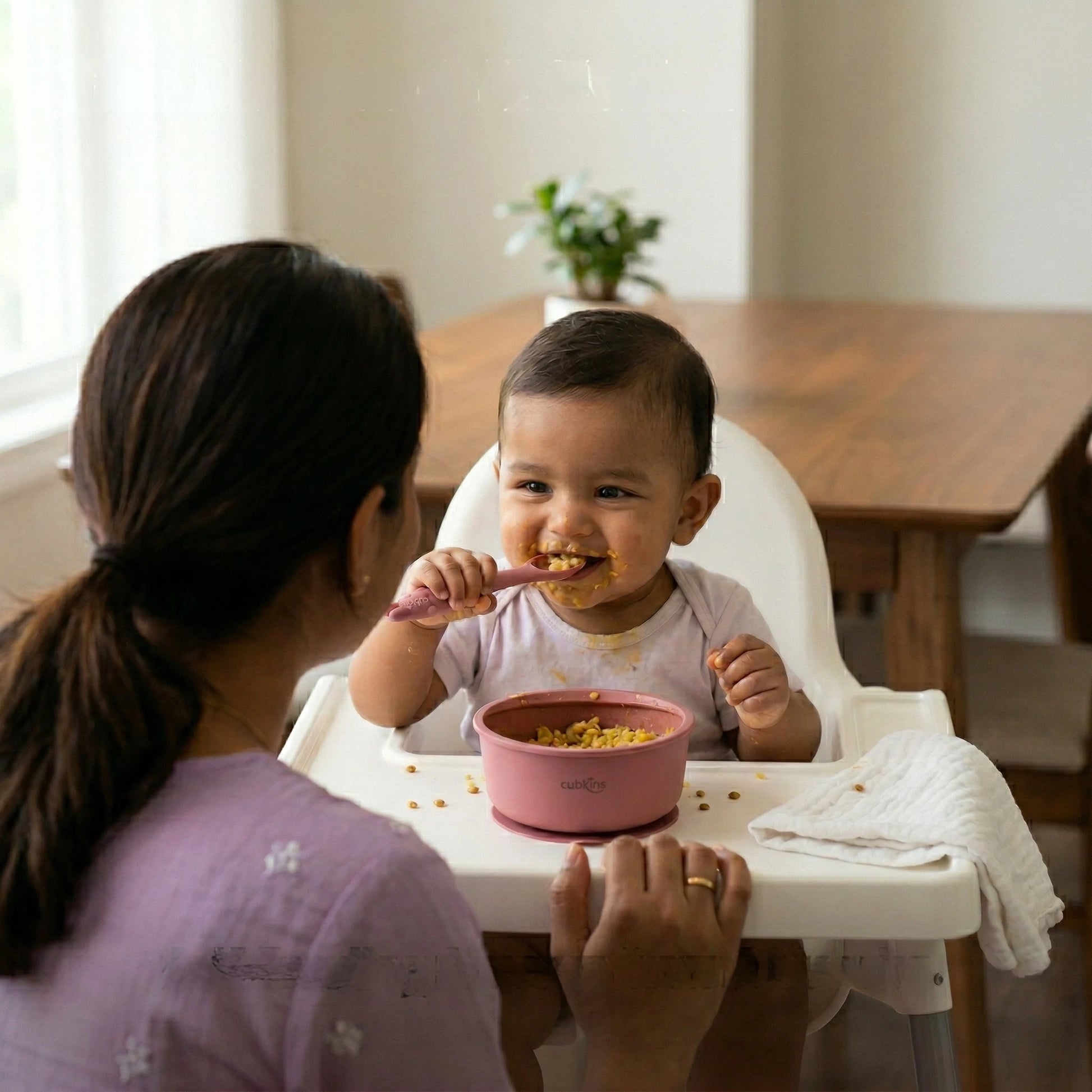 Happy baby self-feeding with Cubkins raspberry ergonomic spoon and suction bowl in high chair