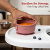 Hand demonstrating strong suction of Cubkins raspberry baby bowl lifting from white tray with pureed food inside