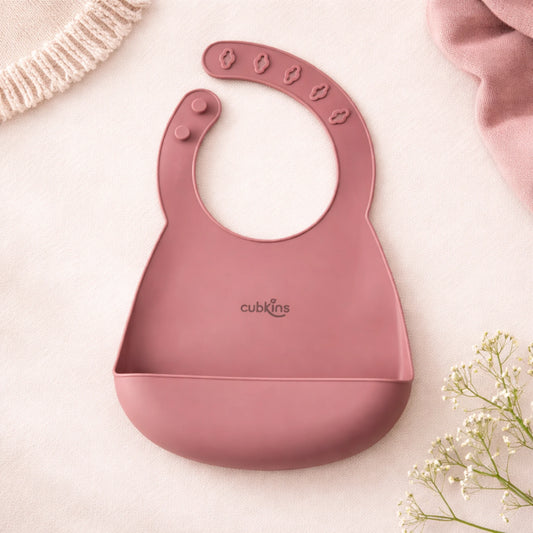 Cubkins silicone baby bib in Raspberry pink color with adjustable snap closure and deep food-catching pocket, displayed flat on neutral background 