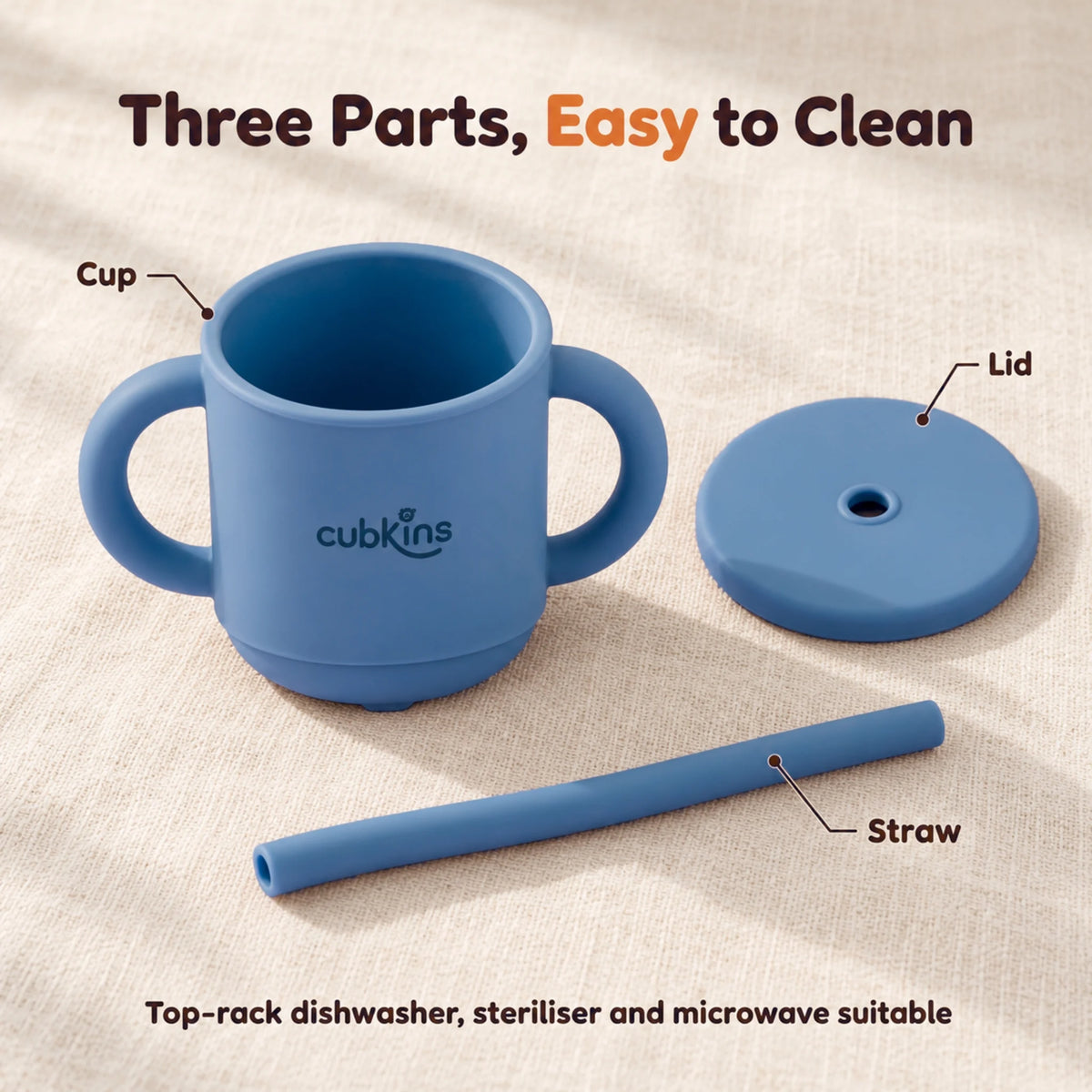 The Cubkins blue olive straw cup taken apart into cup, lid and straw on a cream linen surface