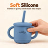 Adult hand gently squeezing the Cubkins blue olive silicone straw cup to show the soft, flexible silicone