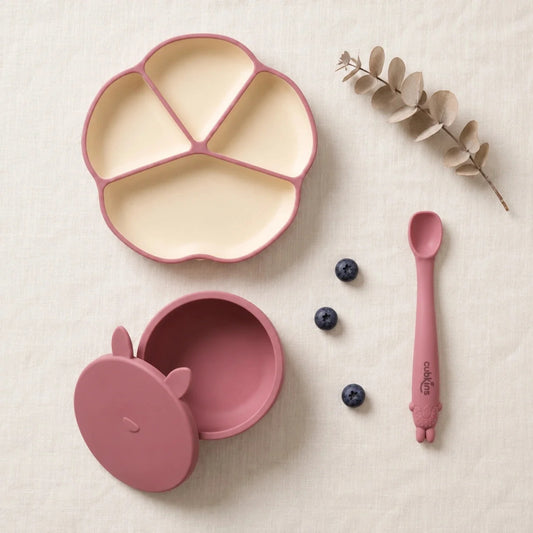 Cubkins plate, bowl and spoon set in Raspberry: silicone suction plate, suction bowl with bunny storage lid and Smart-Bend bendable spoon, top-down on linen