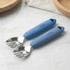 Two Cubkins blue silicone-handle stainless steel baby forks on marble surface — ergonomic grip with textured finger rest for toddler self-feeding