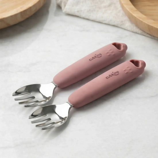 Two Cubkins raspberry silicone-handle stainless steel baby forks on marble surface — soft grip handle safe for toddler self-feeding