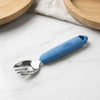 Cubkins stainless steel toddler fork in Blue Olive with food-grade silicone handle, placed on a marble surface with wooden plates in the background