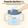 Illustration of a fingertip pressing the air-vent hole on the blue olive lid of the Cubkins straw training cup, pushing the drink up the straw
