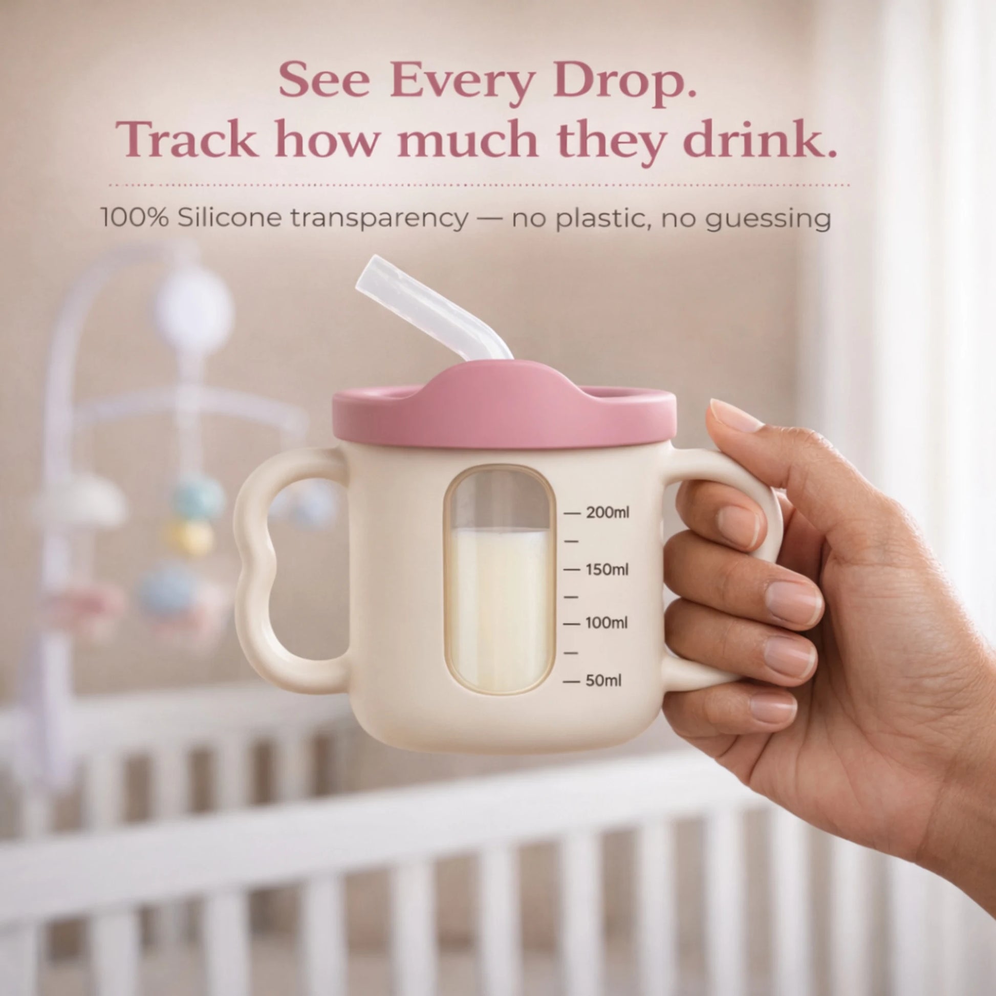 Adult hand holding the Cubkins raspberry pink silicone straw training cup showing the transparent window with measurement markings from 50ml to 200ml to track how much baby drinks