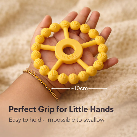 Cubkins Ring Teether in Lemon held in an adult palm showing 10cm diameter – perfect grip size for babies, easy to hold and impossible to swallow