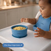 Baby in blue bib eating from Cubkins silicone suction bowl on highchair tray showing fits most highchairs feature