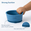 Close-up of Cubkins blue silicone bowl showing strong suction base gripping smooth surface with easy adult release tab